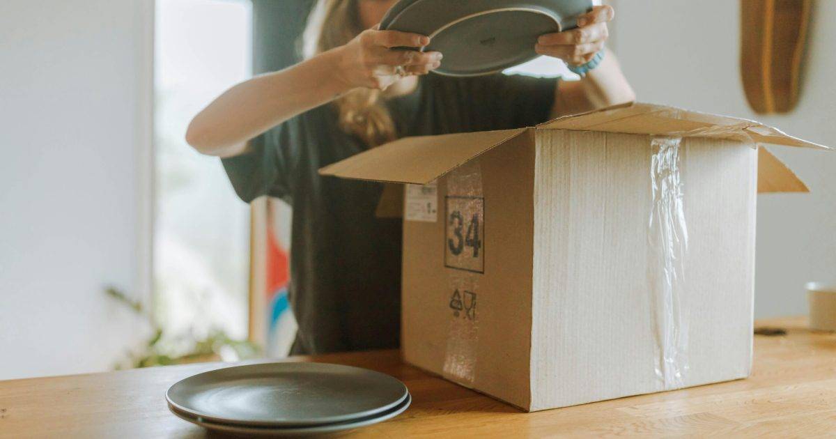 Embalagem de Mudanças especializada Mudança residencial com cliente embalando pratos na caixa